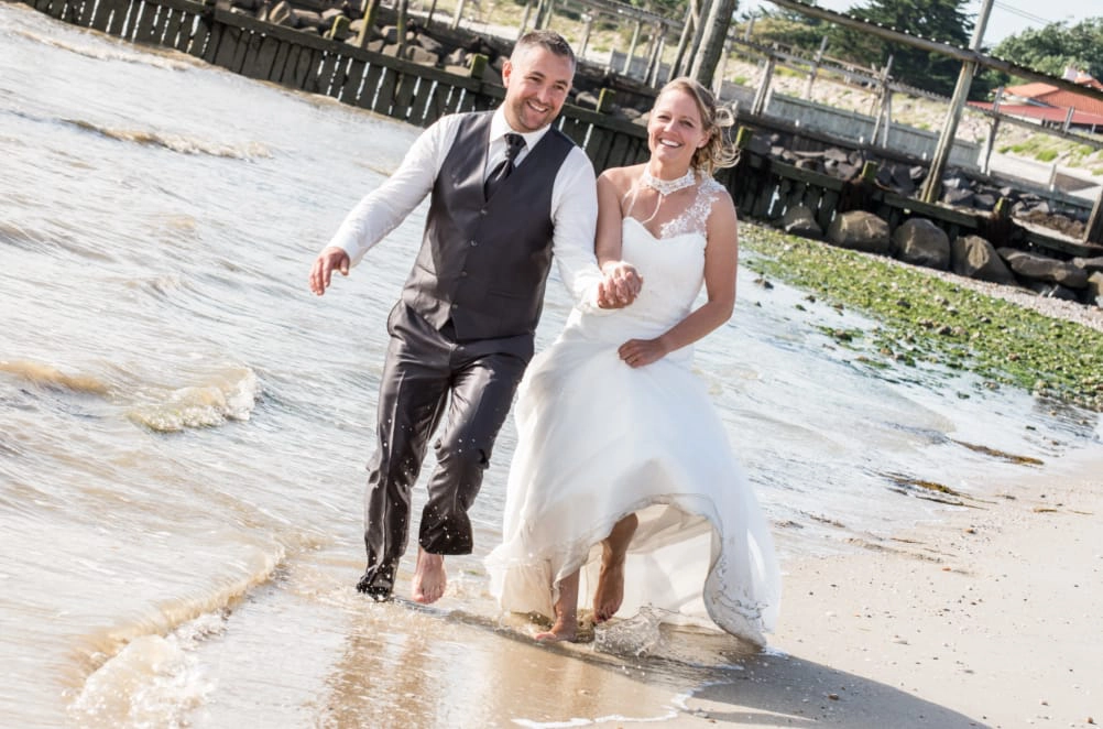 couple de mariés marchant sur la plage